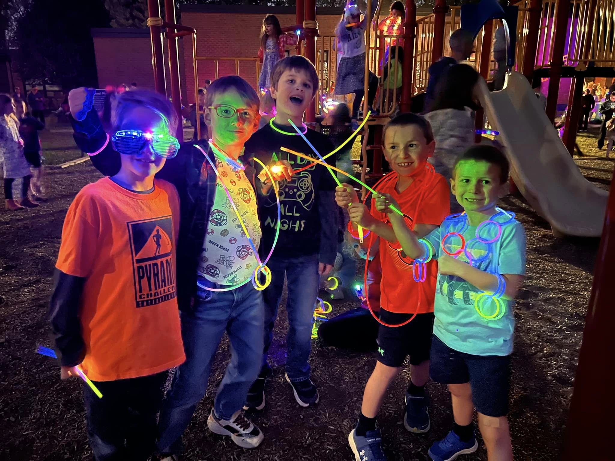 A group of WSES students with glow sticks at the PTA Mustang Glow Party 